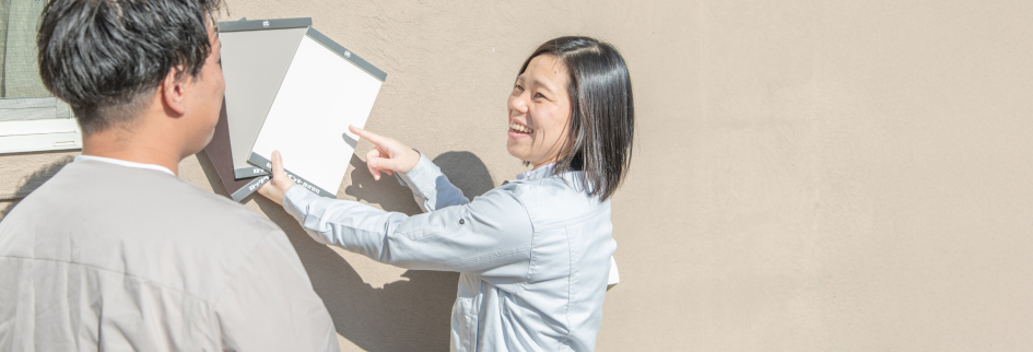 実際に外壁に色板を合わせてお客様と打ち合わせしている様子