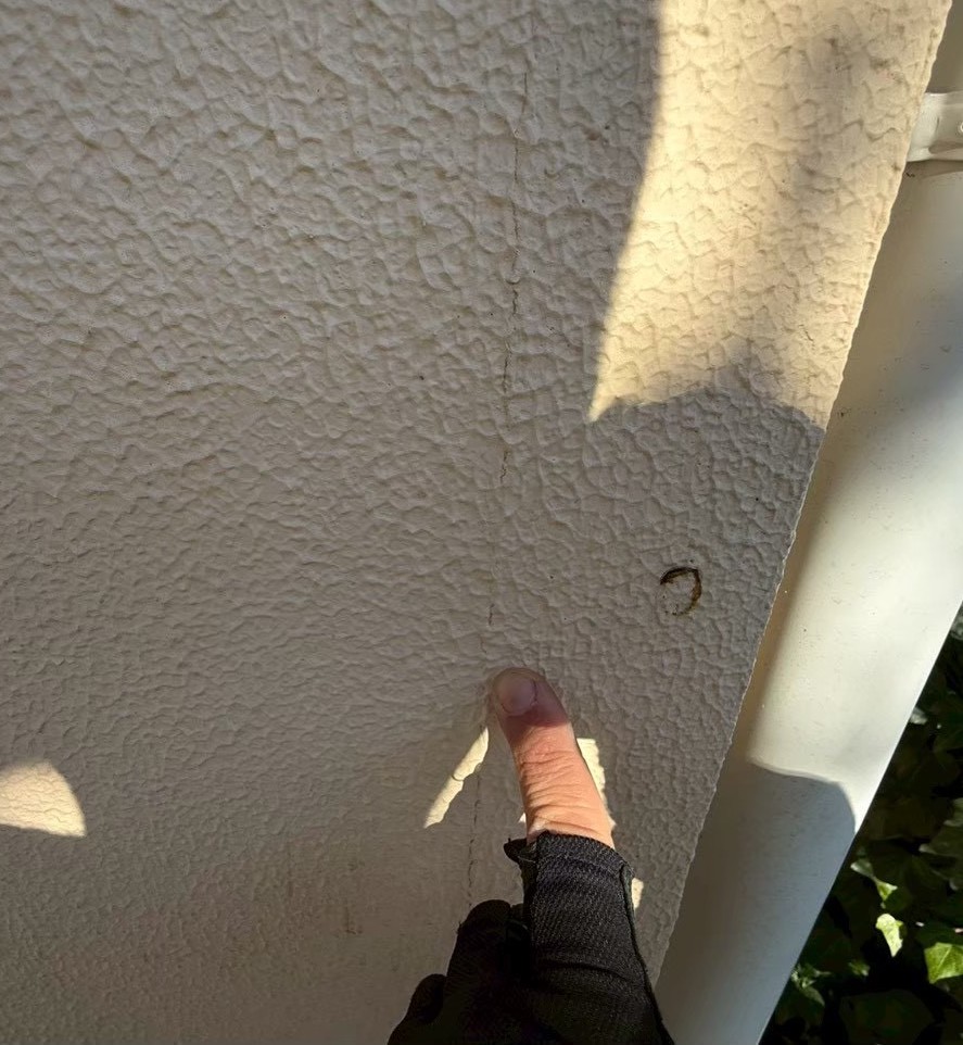 外壁のひび割れを近くで確認している様子