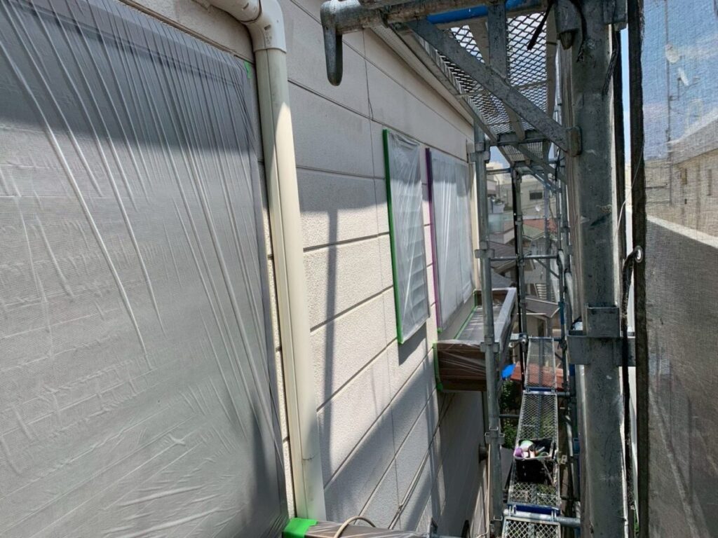 外壁塗装中の窓を養生している様子