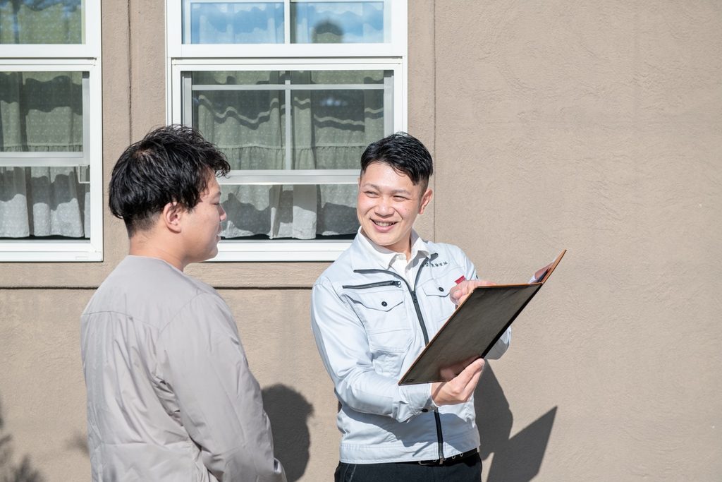 羽村市で外壁塗装についてお客様に説明する職人